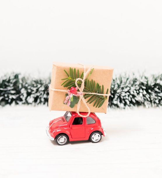 Carro pequeño con un regalo en su techo, representando movilidad y alegría durante las fiestas navideñas en Guatemala.